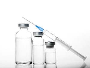 Generic bottles of clear liquid and medical syringe