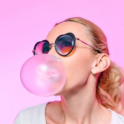 woman blowing pink bubble-gum bubble