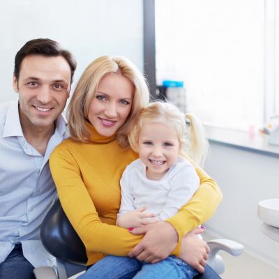 family with young girl smiling at dental office