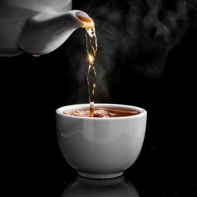 Pouring tea into white mug