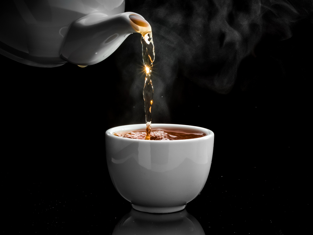 Pouring tea into white mug