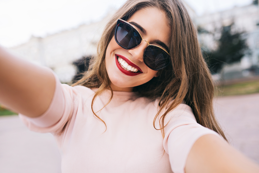 woman with sunglasses taking a selfie