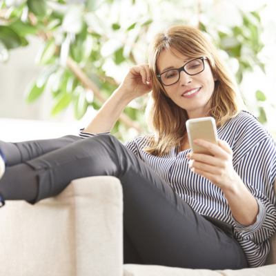 Middle-aged woman relaxing while looking at phone