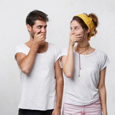 man and woman covering their mouths