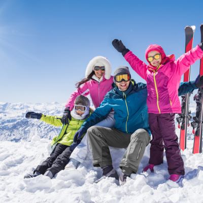 Family on top of mountain skiing in sunshine