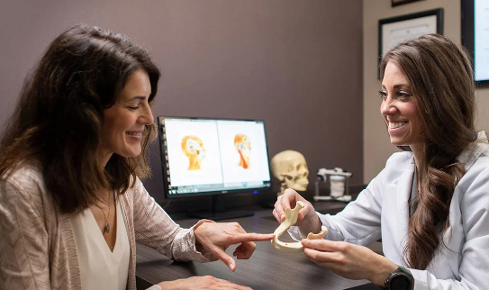 dentist showing patient model of jaw